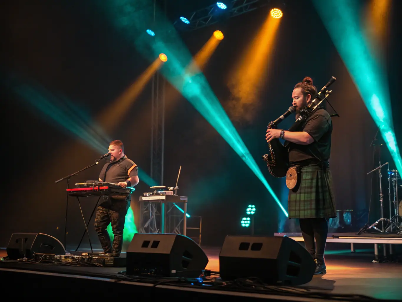 A vibrant image capturing a live performance of Kevrenn An Daou Loupard, showcasing musicians playing traditional Breton instruments in a concert setting. The stage is well-lit, and the audience is visibly engaged and enjoying the music.